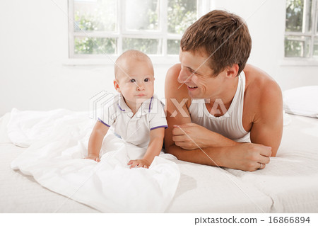 young father with his nine months old son on the bed at home young father with his nine months old son on the bed at home 16866894