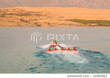 Kids tube riding tawed by speedboat. 16868862
