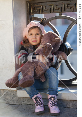 Little girl in a pink beret holds a toy bear Little girl in a pink beret holds a toy bear 16870534