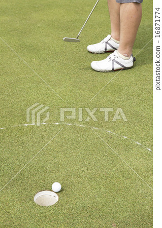 Golf player putting ball into hole Golf player putting ball into hole 16871774