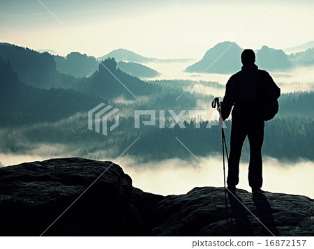 Young man in black sportswear on cliff edge 16872157