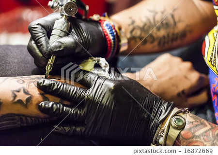 Men putting tattoos in arms Men putting tattoos in arms 16872669