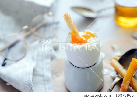 The soft-boiled egg in an eggcup with toasted brea 16873966