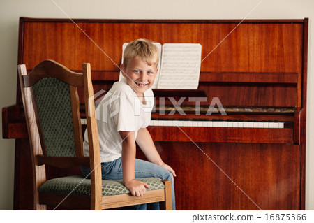 little boy plays piano at home 16875366