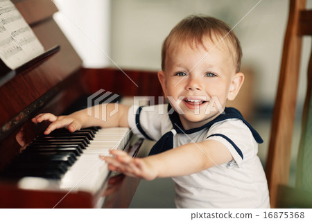 little happy boy plays piano 16875368