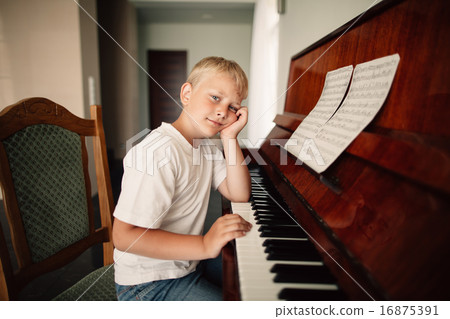 boy plays piano at home 16875391