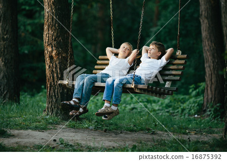 little boys dreaming on swing 16875392
