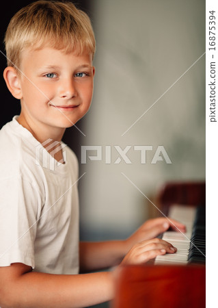 little happy boy plays piano 16875394