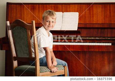 little happy boy plays piano 16875396