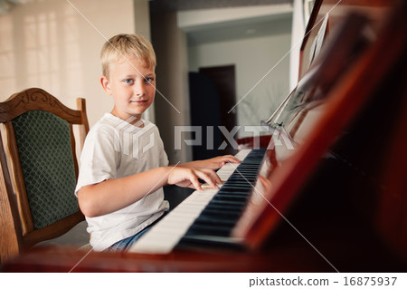 little happy boy plays piano 16875937