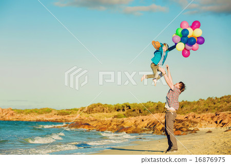 Happy father and son having great time on the beach in sunset light 16876975