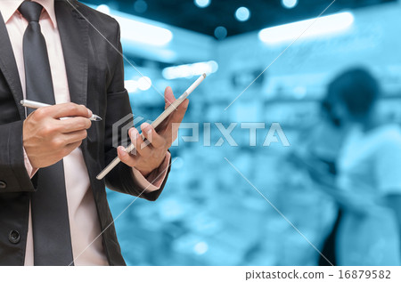 Businessman using the tablet on on Abstract blurred photo of boo 16879582