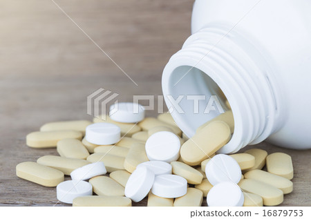 Many Pills and vitamin in Medicine bottles on wood background Many Pills and vitamin in Medicine bottles on wood background 16879753
