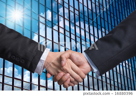 Hand shake between a businessman on Modern glass building backgr 16880396