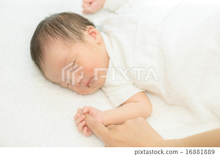 Newborn sleeping wrapped in white spirit 16881889