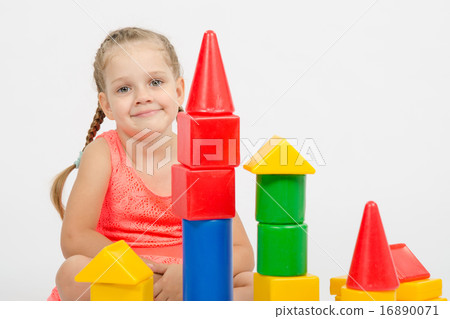 The four-year girl sits at a house out of blocks The four-year girl sits at a house out of blocks 16890071