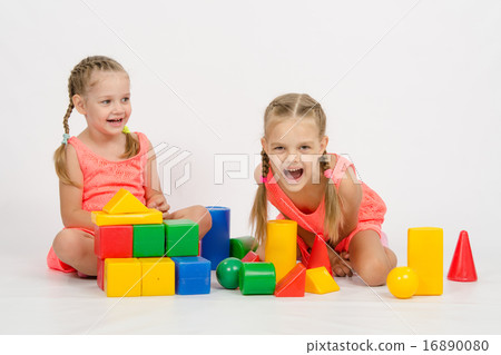 Two girls laughing uncontrollably playing dice Two girls laughing uncontrollably playing dice 16890080
