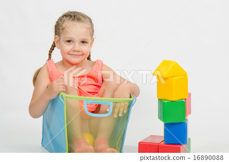 The girl climbed into a box for toys The girl climbed into a box for toys 16890088
