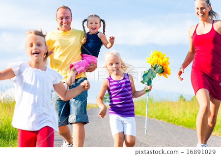 Family running down hill in summer 16891029