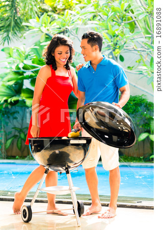 Asian couple having barbecue at the pool 16891088