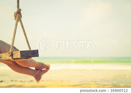 Woman leg on a swing at tropical sea beach Woman leg on a swing at tropical sea beach 16900512