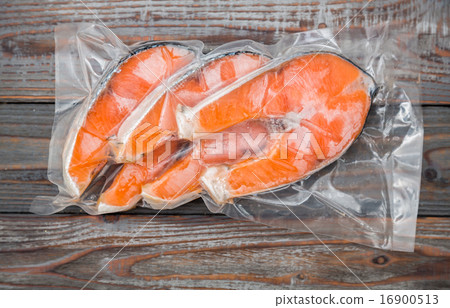 Frozen salmon fillets in a vacuum package wood table Frozen salmon fillets in a vacuum package wood table 16900513
