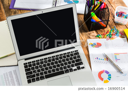 Financial charts on the table with laptop Financial charts on the table with laptop 16900514