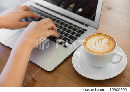Closeup of business woman hand typing on laptop keyboard and cof Closeup of business woman hand typing on laptop keyboard and cof 16900893