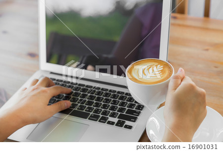 Closeup of business woman hand typing on laptop keyboard and cof Closeup of business woman hand typing on laptop keyboard and cof 16901031