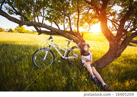 cute sportswoman Cyclist resting under a tree cute sportswoman Cyclist resting under a tree 16905209