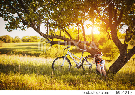 cute sportswoman Cyclist resting under a tree 16905210