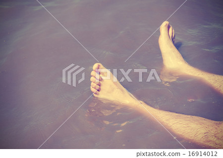 Vintage filtered male bare feet in lake water. Vintage filtered male bare feet in lake water. 16914012