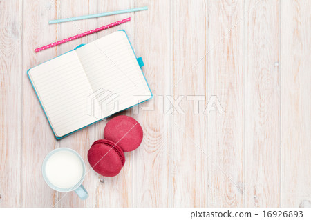 Cup of milk and macarons on white wooden table Cup of milk and macarons on white wooden table 16926893