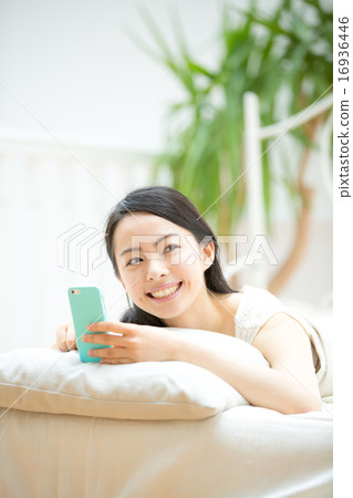 A young lady watching smartphone in bed 16936446