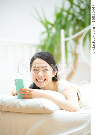 A young lady watching smartphone in bed 16936447