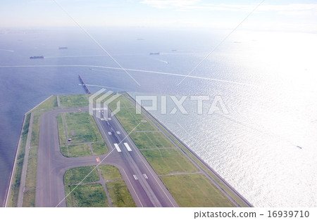 羽田東京國際機場的D跑道突出在銀色燃燒的東京灣 羽田東京國際機場的D跑道突出在銀色燃燒的東京灣 16939710