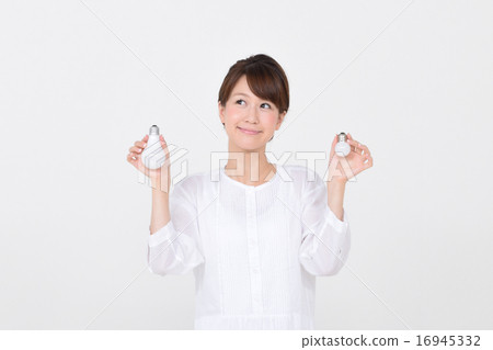 拿著一個電燈泡在兩隻手中的婦女 16945332