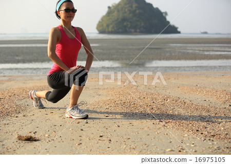 young woman stretching on sunrise beach 16975105