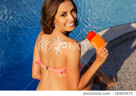 Sun shape drawing from sunscreen lotion on girls shoulder Sun shape drawing from sunscreen lotion on girls shoulder 16984875