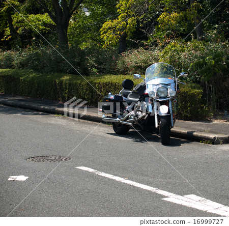 A large motorbike stopped at the side of the park 16999727