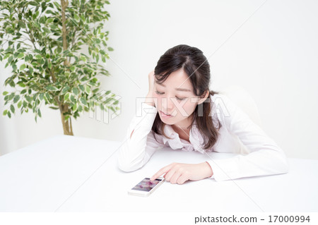 A young woman waiting for a phone call or e-mail OL 17000994