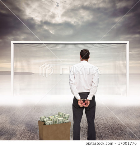Composite image of rear view of young businessman wearing handcu Composite image of rear view of young businessman wearing handcu 17001776