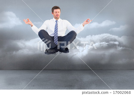 Composite image of businessman meditating in lotus pose Composite image of businessman meditating in lotus pose 17002068