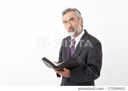 A senior businessman with a book A senior businessman with a book 17006403