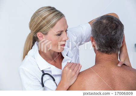 Doctor examining her patient shoulder Doctor examining her patient shoulder 17006809