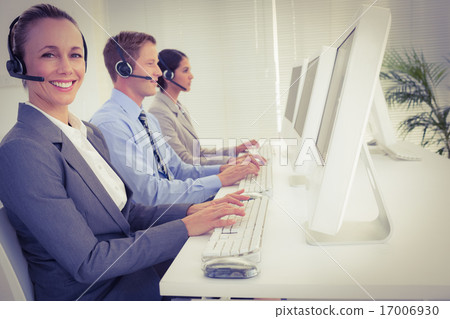 Business team working on computers and wearing headsets Business team working on computers and wearing headsets 17006930
