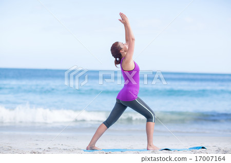 Brunette doing yoga on exercise mat 17007164