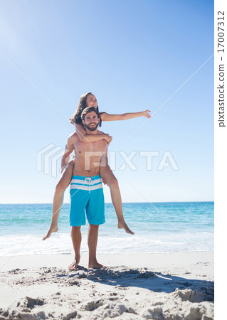 Handsome man giving piggy back to his girlfriend Handsome man giving piggy back to his girlfriend 17007312