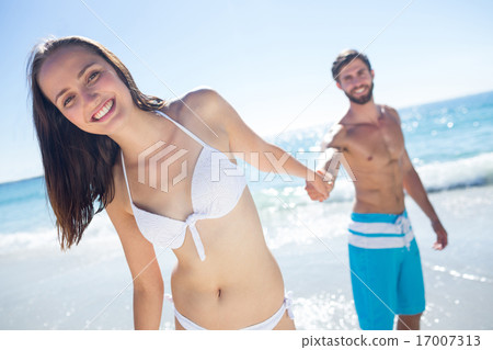 Smiling couple holding hands and looking at camera Smiling couple holding hands and looking at camera 17007313