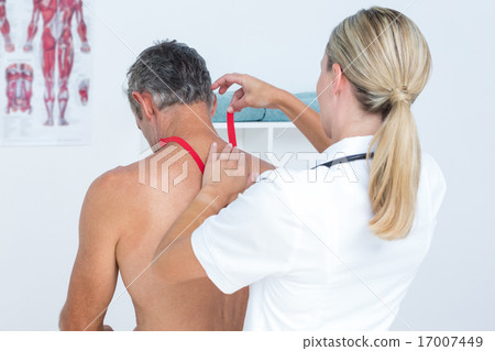 Doctor examining her patient back Doctor examining her patient back 17007449